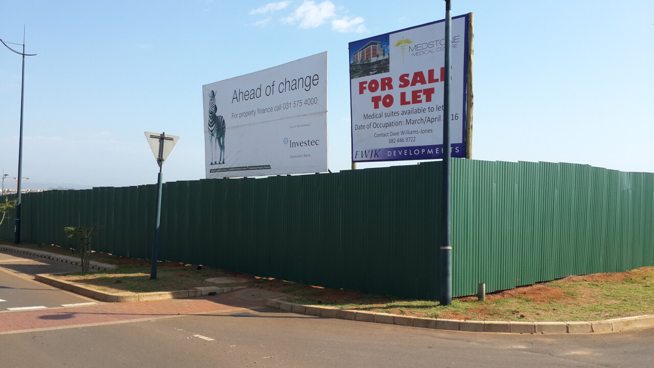 Galvanised steel hoarding and site-screening panels painted green.