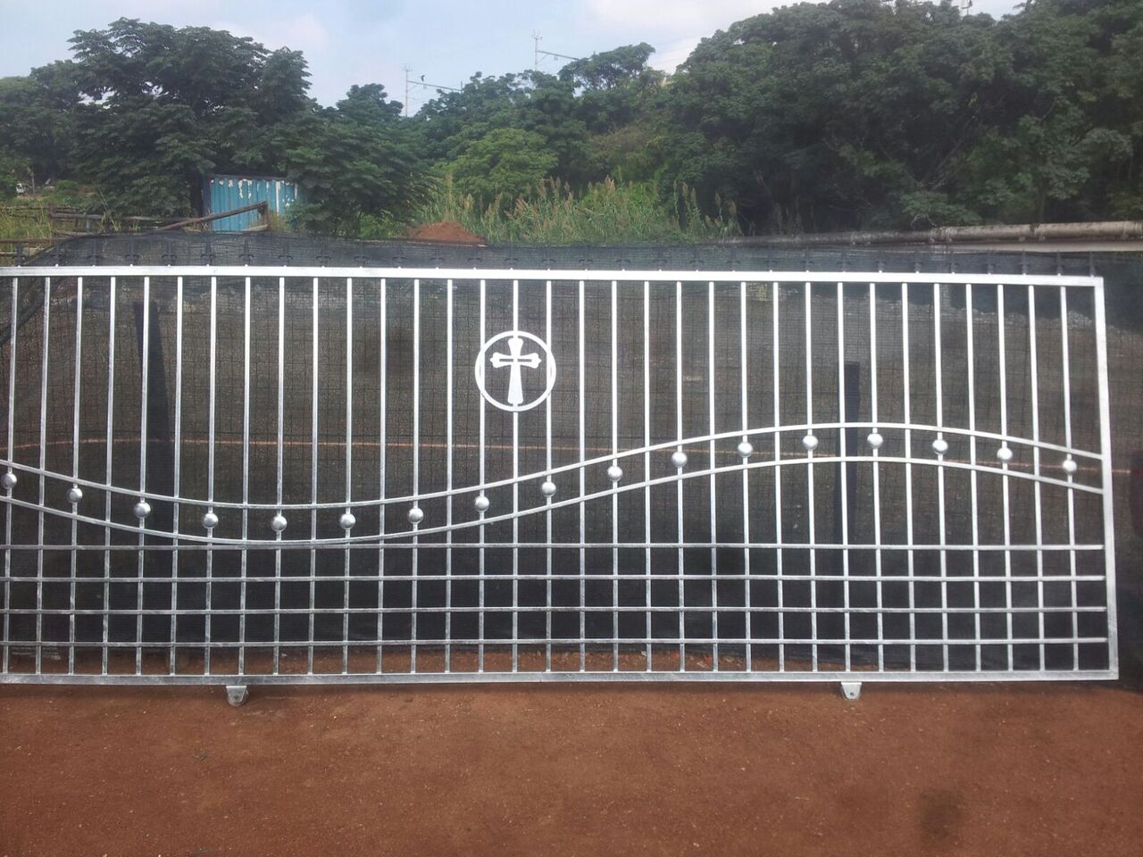 A steel sliding gate with a decorative panel design.