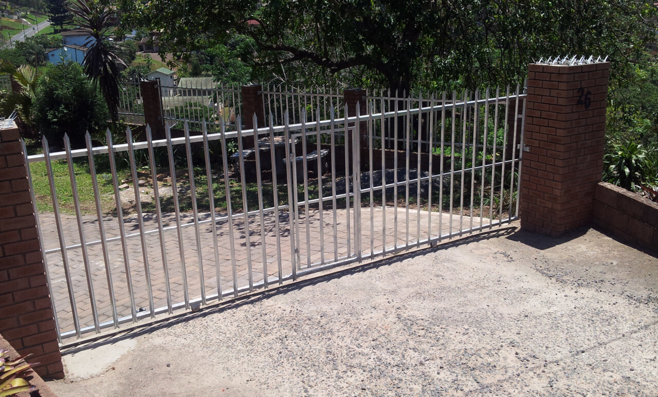 A steel palisade sliding gate on its track, part of a steel palisade perimeter — a completed Verulam Fencing job.